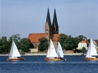 Zu sehen sind Segelboote auf dem Ruppiner See vor der Klosterkirche.